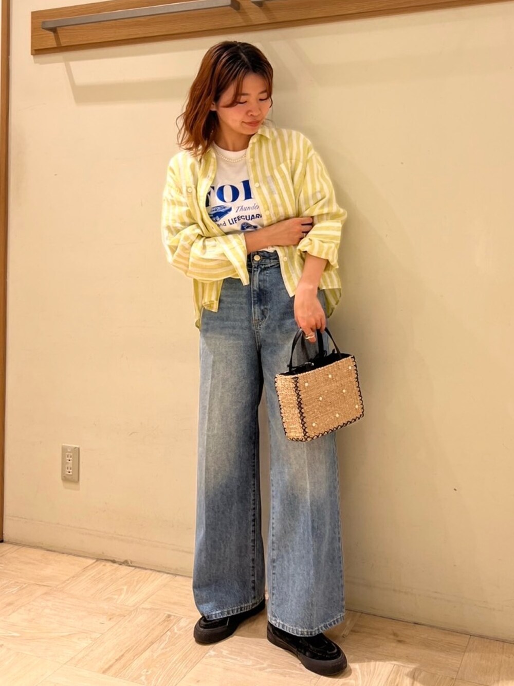 ブルー系のデニムパンツ、イエロー系のシャツ/ブラウス、ホワイト系のTシャツ/カットソーを着用したレディースの春コーディネートの2枚目の写真