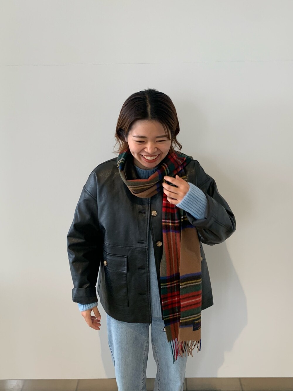 ブルー系のデニムパンツ、ブラック系のブルゾン、ブルー系のニット/セーターを着用したレディースの秋コーディネートの4枚目の写真