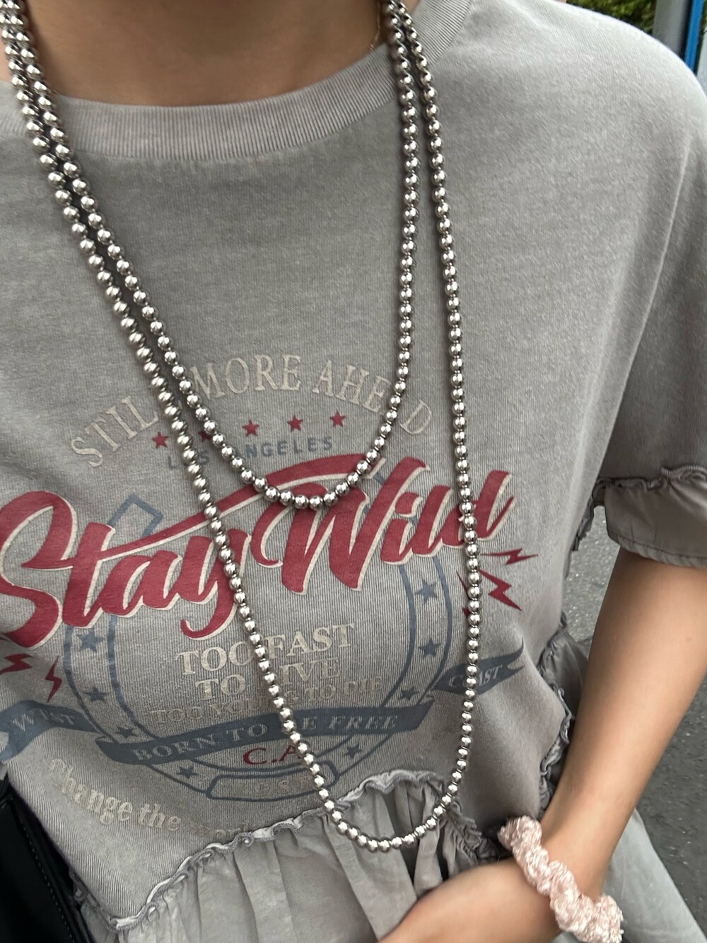 グレー系のTシャツ/カットソー、ブラック系のハンドバッグ、シルバー系のサンダルを着用したレディースの夏コーディネートの5枚目の写真
