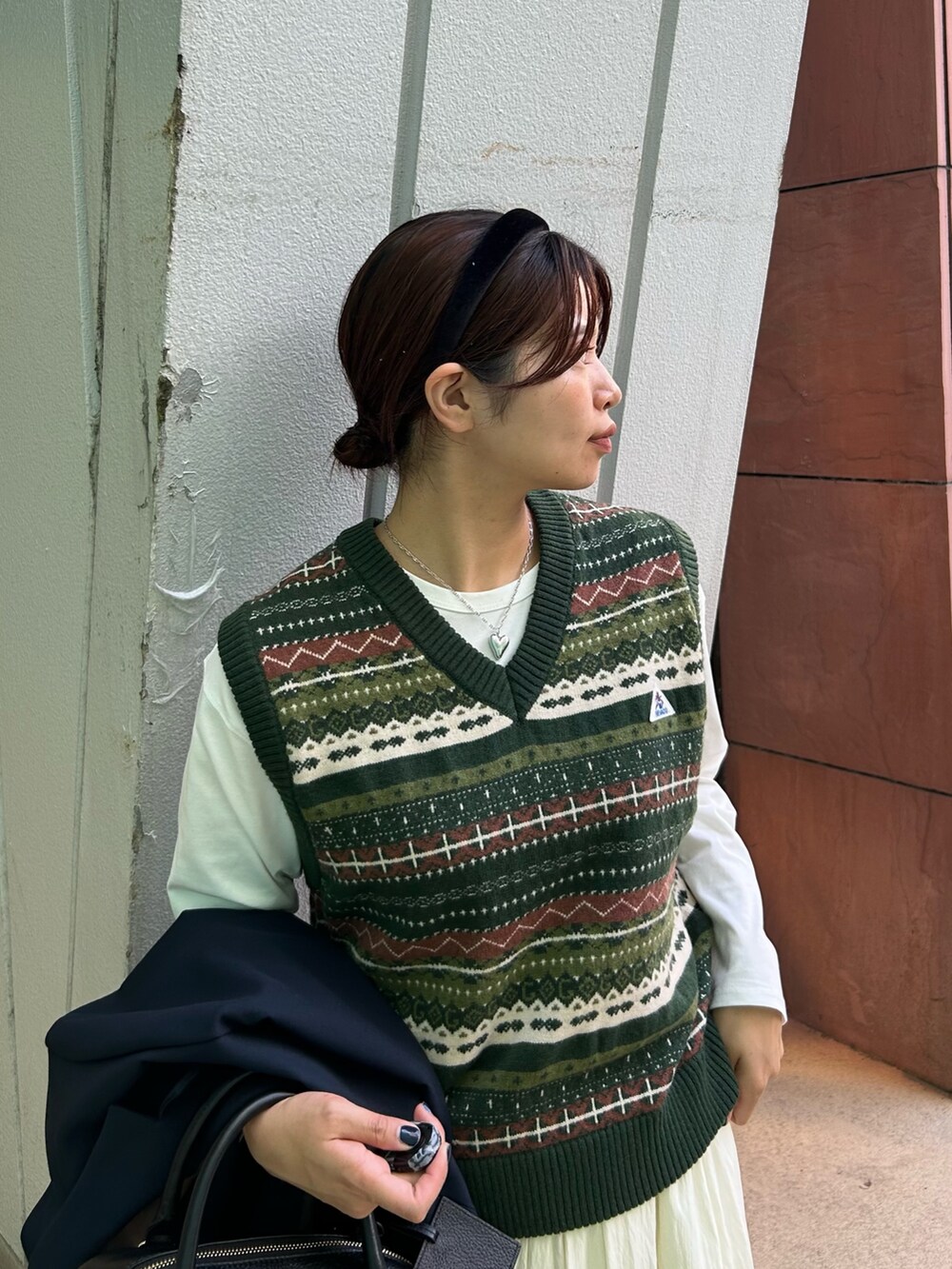 ブルー系のテーラードジャケット、グリーン系のベスト、ホワイト系のTシャツ/カットソーを着用したレディースの秋コーディネートの4枚目の写真