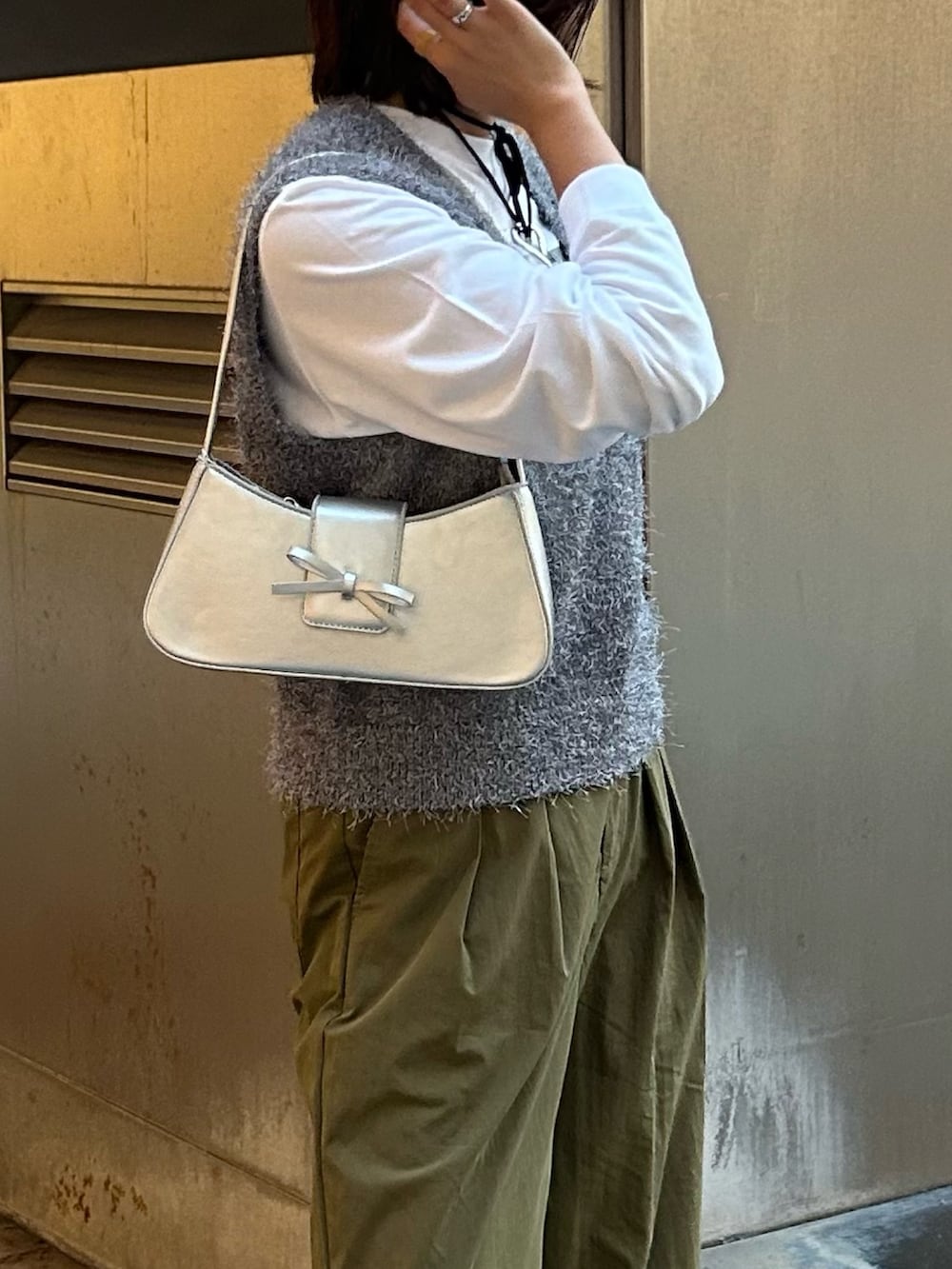 グリーン系のその他パンツ、グレー系のベスト、シルバー系のハンドバッグを着用したレディースの秋コーディネートの6枚目の写真