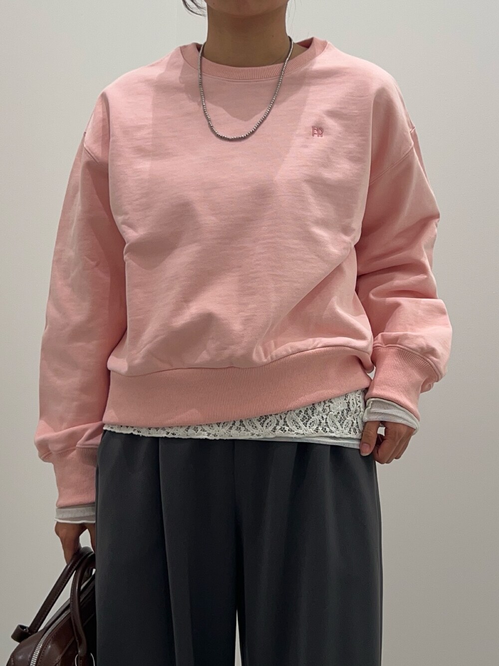 グレー系のその他パンツ、ブラウン系のショルダーバッグ、ピンク系のスウェットを着用したレディースの冬コーディネートの5枚目の写真