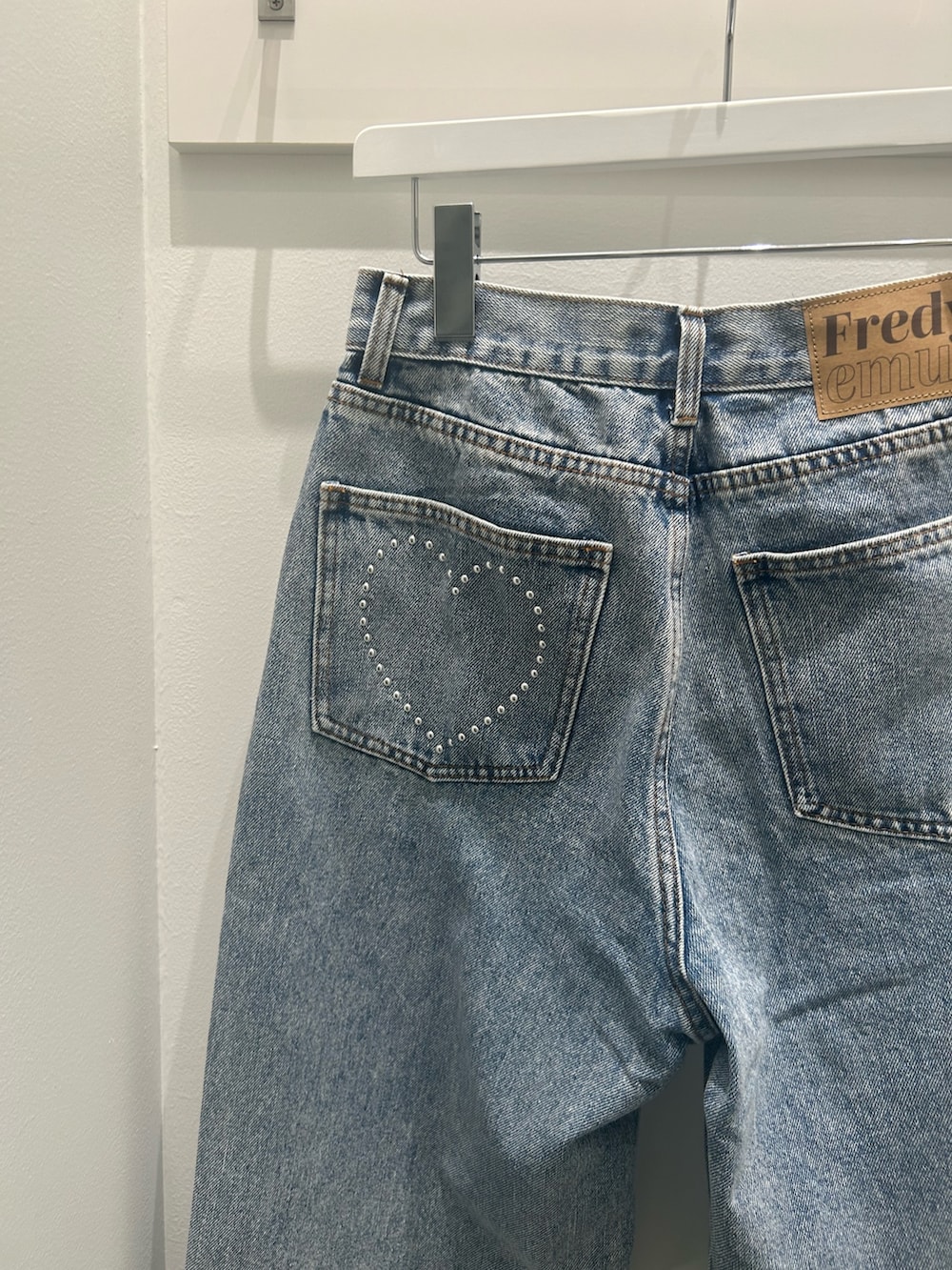 ベージュ系のトレンチコート、ブラック系のショルダーバッグ、ブルー系のデニムパンツを着用したレディースの冬コーディネートの6枚目の写真