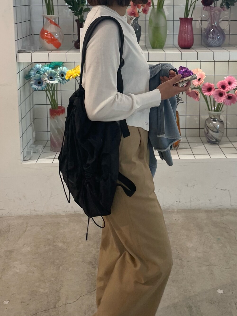 ベージュ系のその他パンツ、ホワイト系のカーディガン/ボレロ、ブルー系のシャツ/ブラウスを着用したレディースの春コーディネートの4枚目の写真