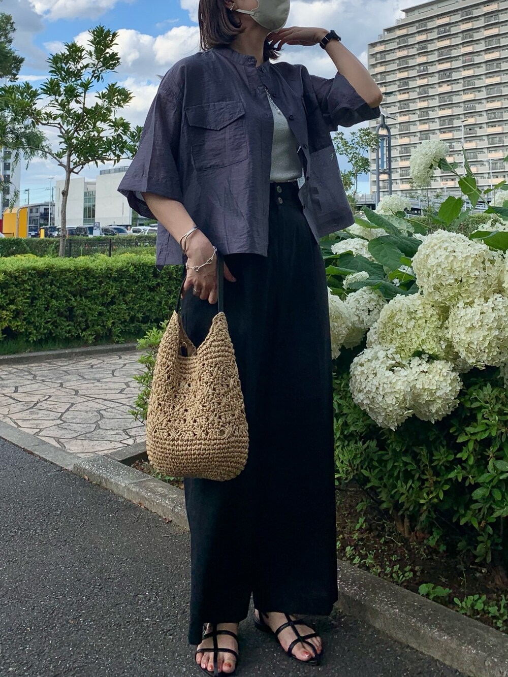 ブラック系のかごバッグ、ブラック系のスラックス、グレー系のシャツ/ブラウスを着用したレディースの夏コーディネートの3枚目の写真