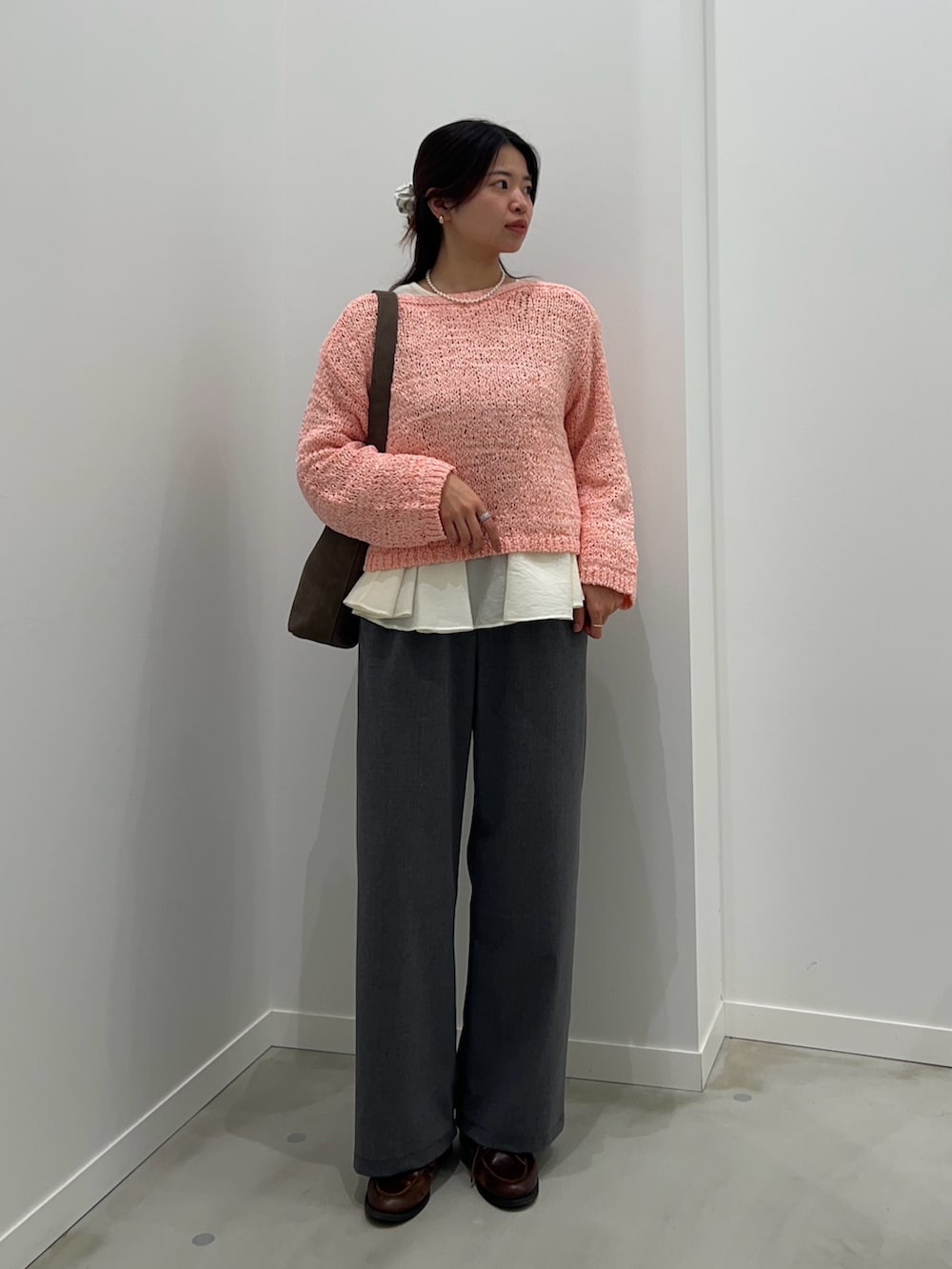 グレー系のその他パンツ、ピンク系のニット/セーター、ホワイト系のシャツ/ブラウスを着用したレディースの春コーディネートの2枚目の写真