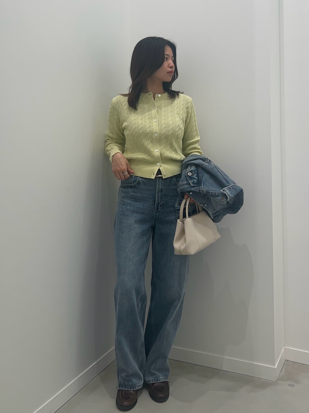 ブルー系のデニムパンツ、ブルー系のデニムジャケット、グリーン系のカーディガン/ボレロを着用したレディースの冬コーディネートの3枚目の写真