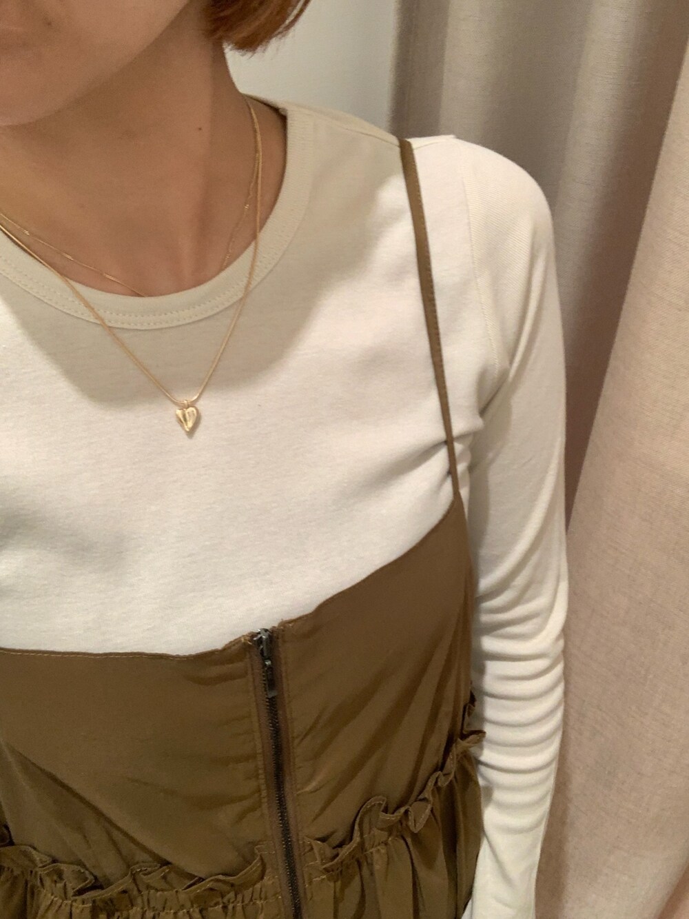 イエロー系のワンピース、ホワイト系のTシャツ/カットソー、ブルー系のデニムパンツを着用したレディースの秋コーディネートの4枚目の写真