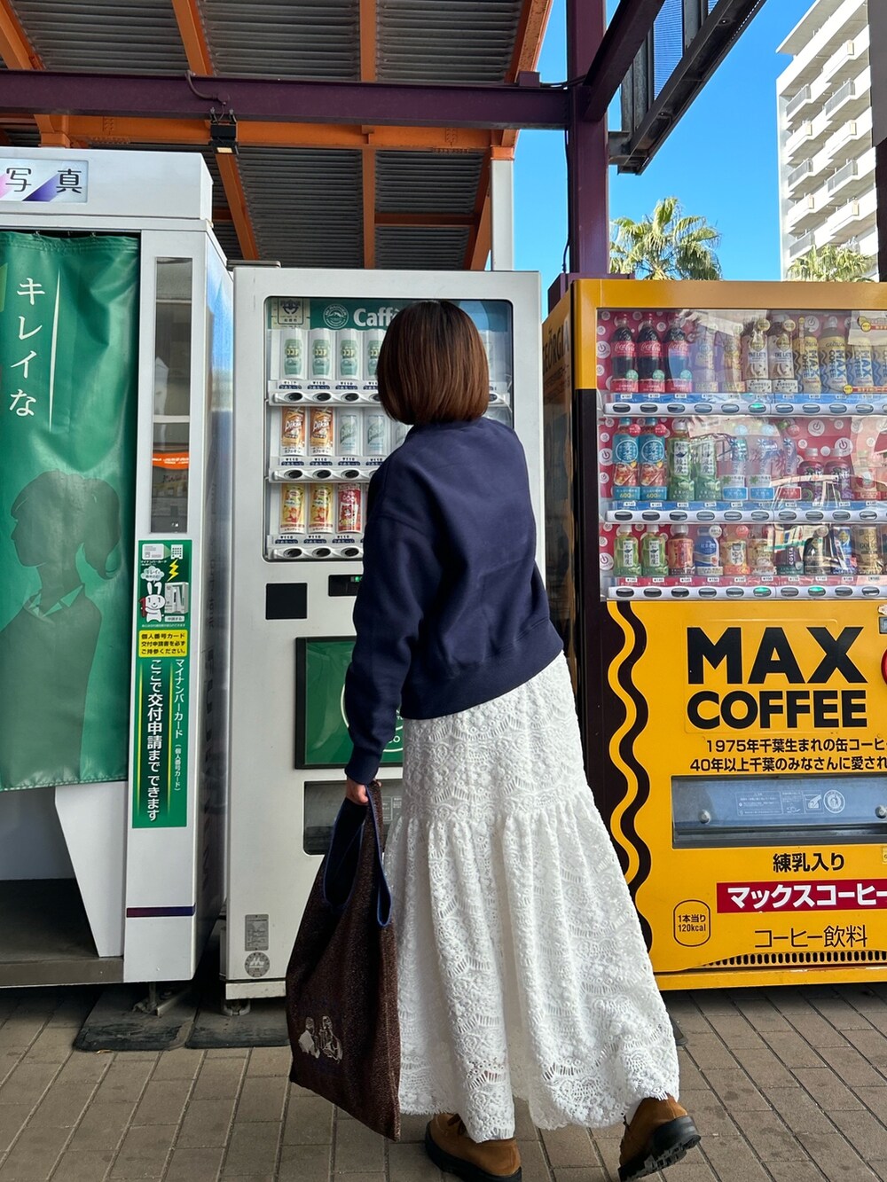 ブルー系のスウェット、ホワイト系のスカート、ブラウン系のショルダーバッグを着用したレディースの冬コーディネートの5枚目の写真