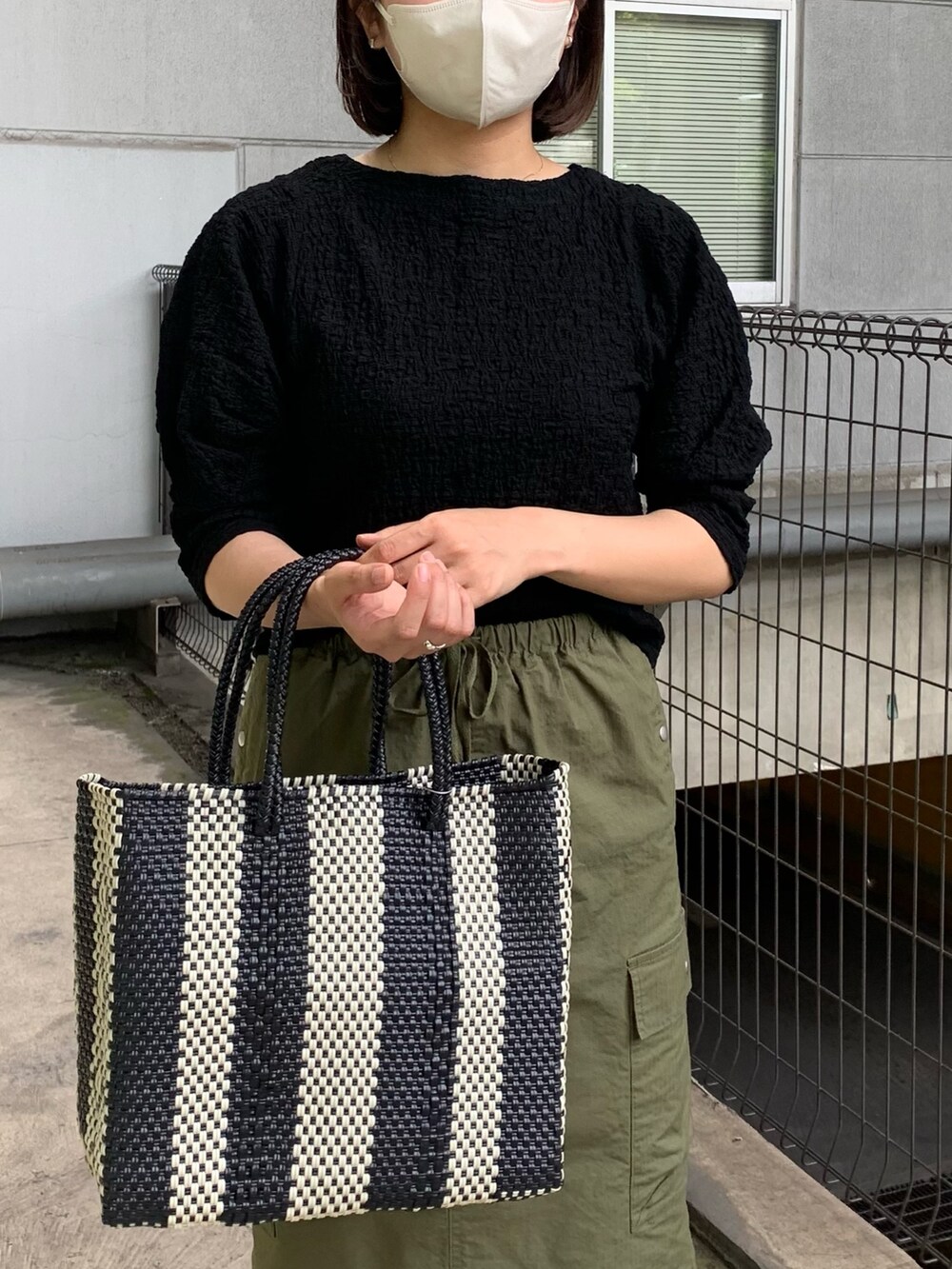 ブラック系のTシャツ/カットソー、グリーン系のスカートを着用したレディースの春コーディネートの4枚目の写真