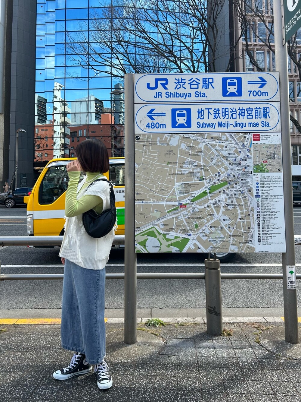 ブルー系のデニムスカート、ホワイト系のベスト、イエロー系のTシャツ/カットソーを着用したレディースの春コーディネートの4枚目の写真