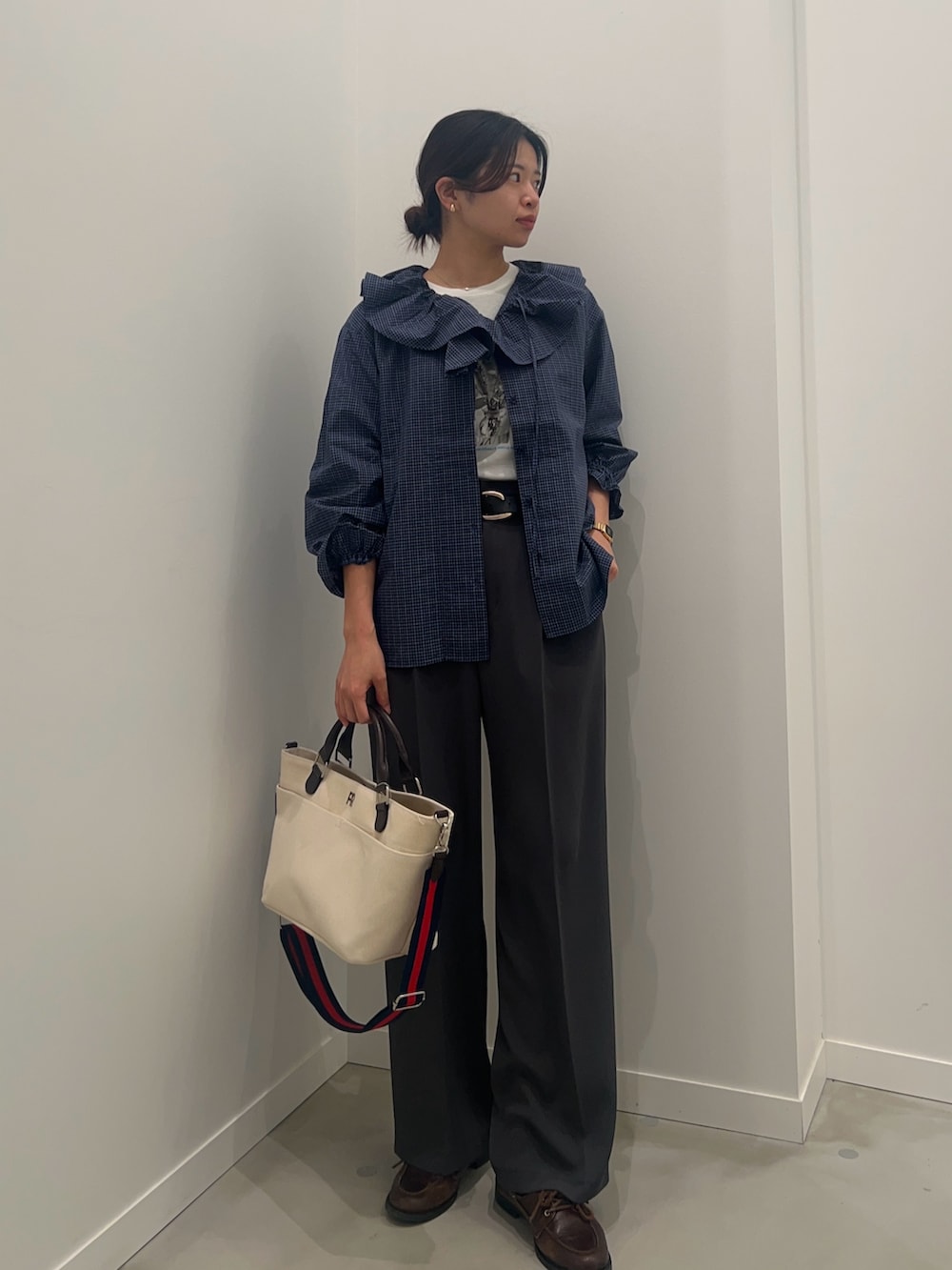 ホワイト系のTシャツ/カットソー、グレー系のスラックス、ホワイト系のショルダーバッグを着用したレディースの春コーディネートの4枚目の写真