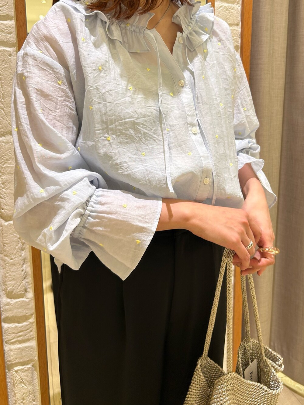 ブラック系のスラックス、シルバー系のトートバッグ、ブルー系のシャツ/ブラウスを着用したレディースの春コーディネートの5枚目の写真