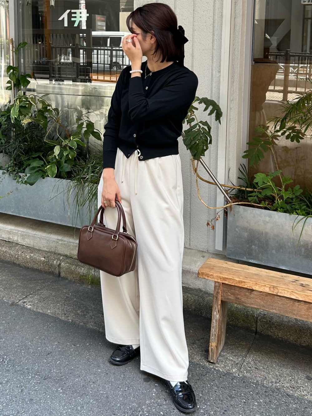 ホワイト系のその他パンツ、ブラウン系のハンドバッグ、ブラック系のニット/セーターを着用したレディースの秋コーディネートの4枚目の写真