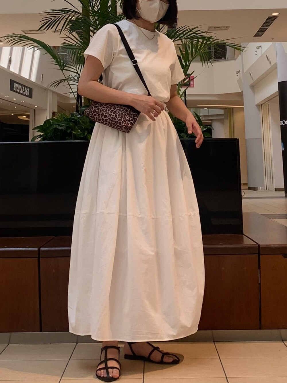 ホワイト系のワンピース、ブラック系のサンダル、ゴールド系のネックレスを着用したレディースの春コーディネートの4枚目の写真