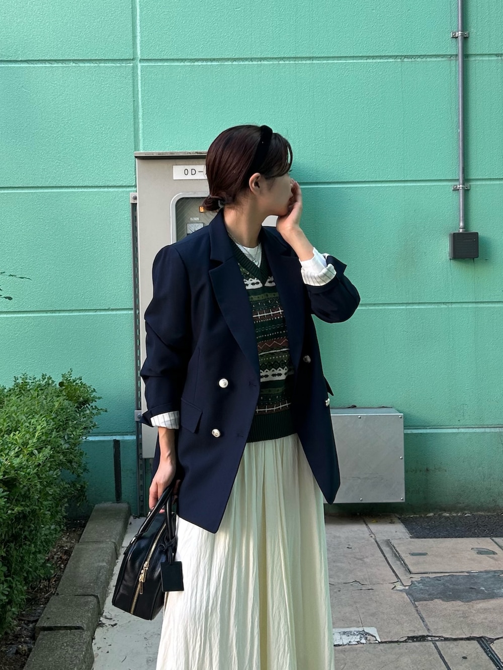 ブルー系のテーラードジャケット、グリーン系のベスト、ホワイト系のTシャツ/カットソーを着用したレディースの秋コーディネートの2枚目の写真