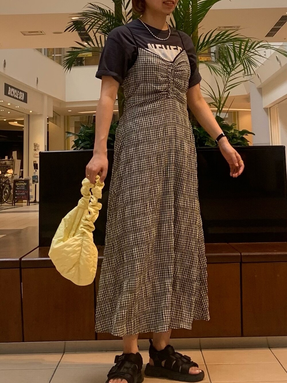 ブラック系のワンピース、グレー系のTシャツ/カットソー、イエロー系のショルダーバッグを着用したレディースの夏コーディネートの3枚目の写真