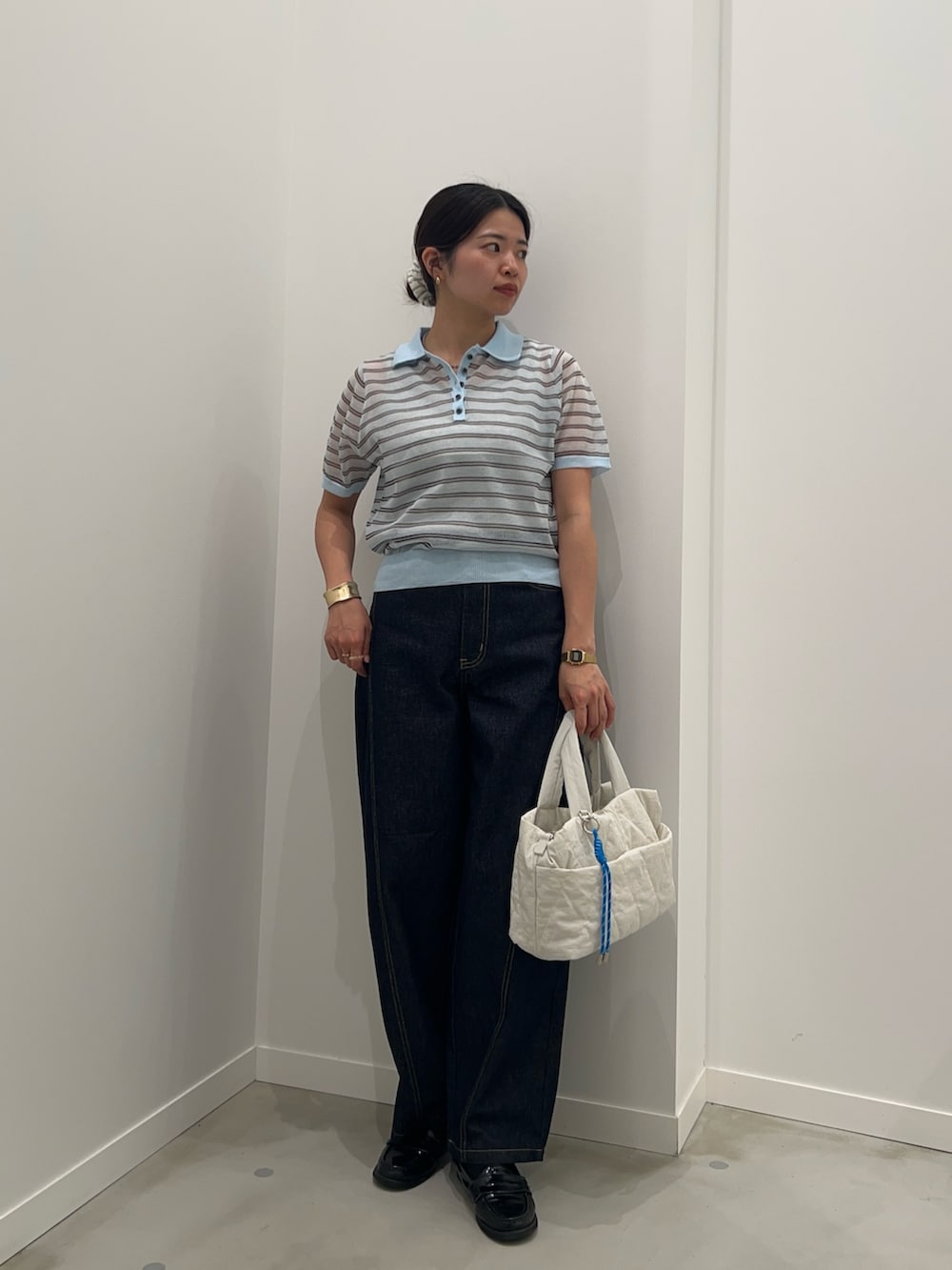 グレー系のタンクトップ、ブルー系のデニムパンツ、ブルー系のポロシャツを着用したレディースの夏コーディネートの3枚目の写真