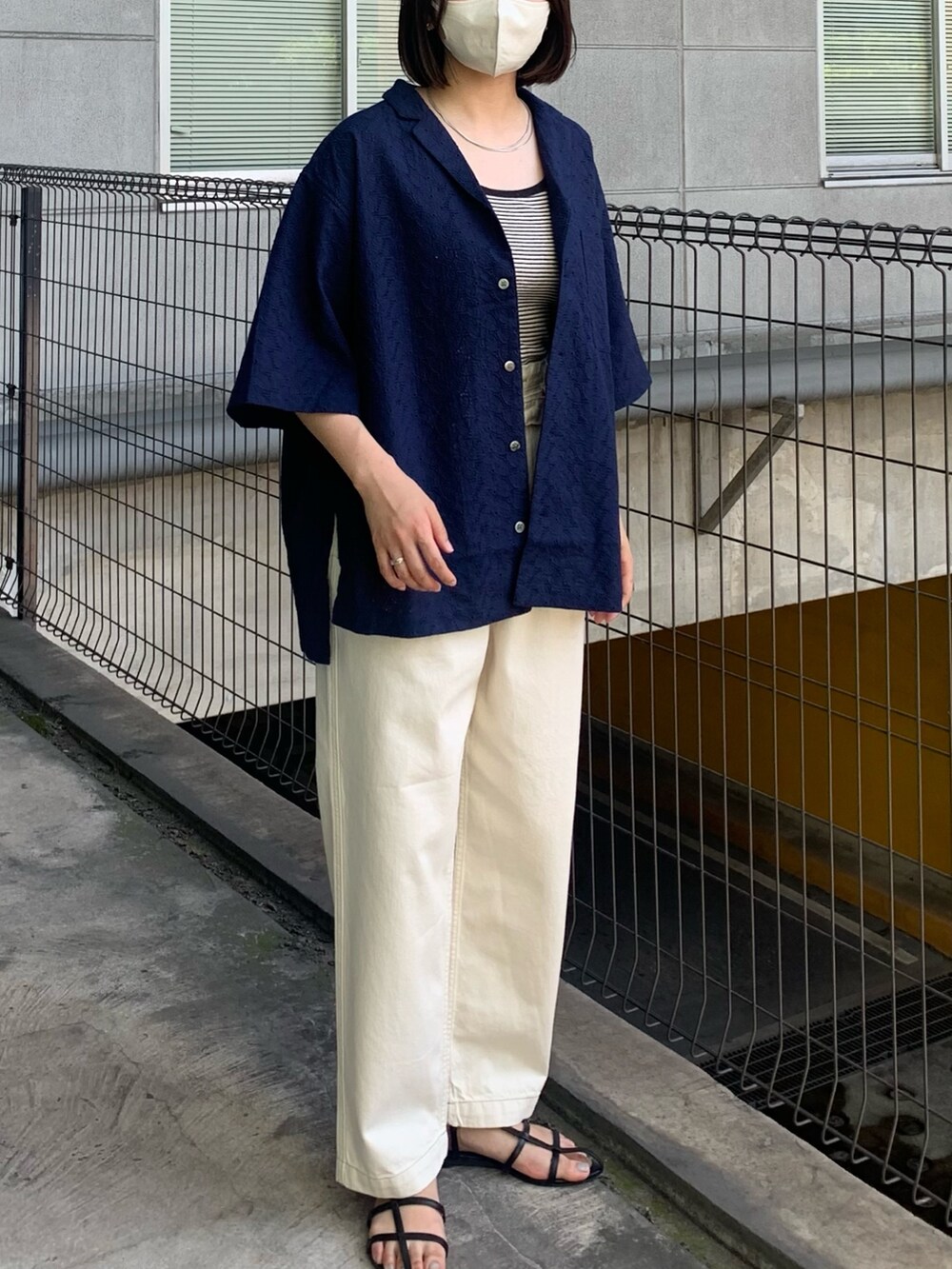 ブルー系のシャツ/ブラウス、ホワイト系のデニムパンツ、ブラック系のサンダルを着用したレディースの春コーディネートの2枚目の写真