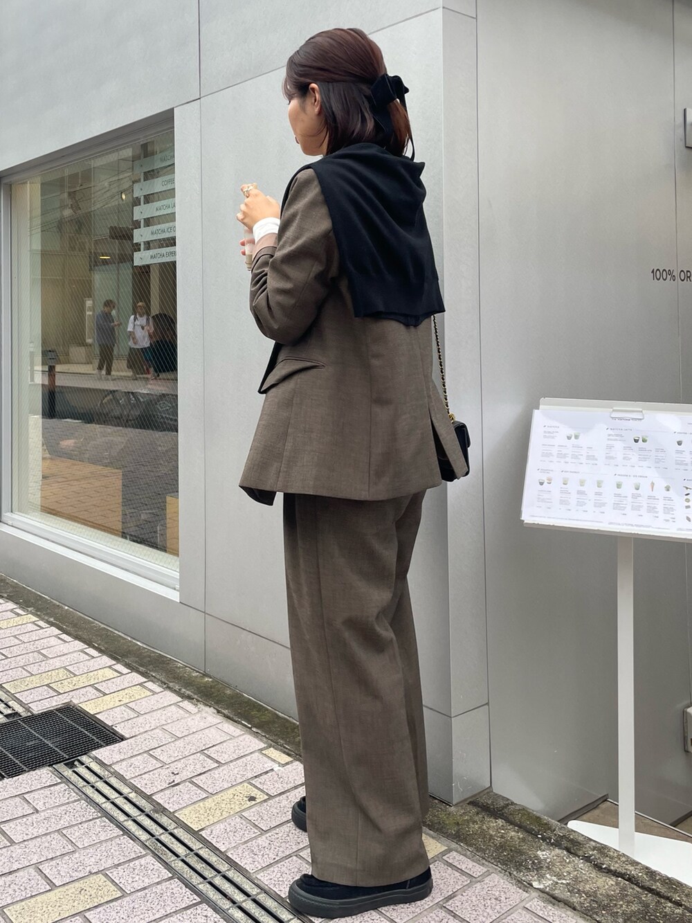ブラウン系のスラックス、ブラウン系のノーカラージャケット、ホワイト系のTシャツ/カットソーを着用したレディースの秋コーディネートの2枚目の写真