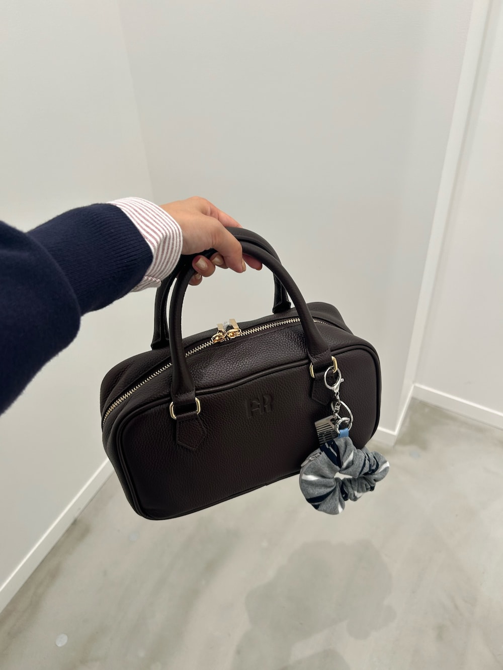 レッド系のシャツ/ブラウス、ブルー系のデニムパンツ、ブラウン系のボストンバッグを着用したレディースの秋コーディネートの5枚目の写真