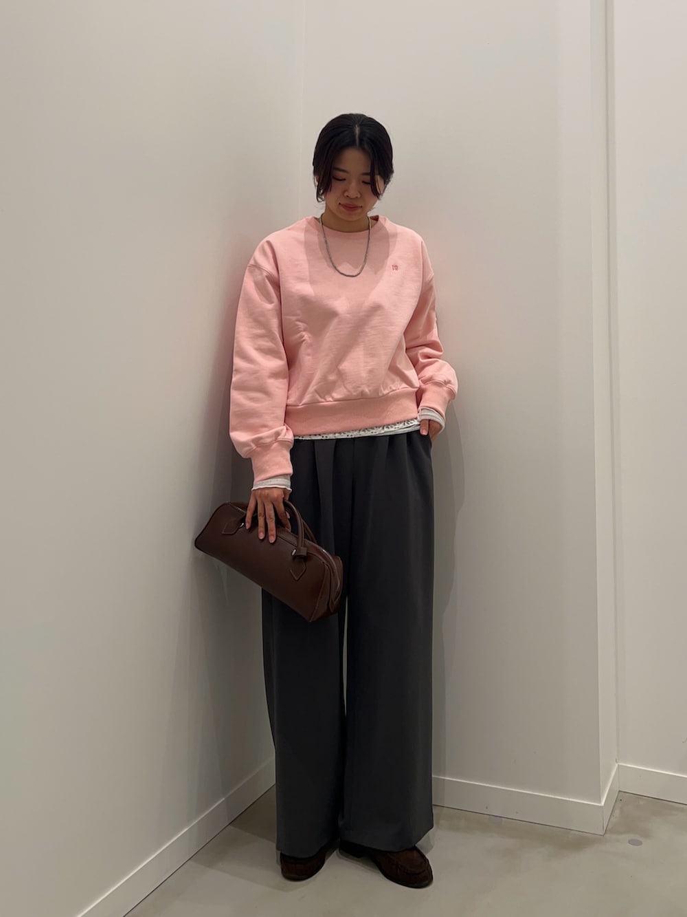 グレー系のその他パンツ、ブラウン系のショルダーバッグ、ピンク系のスウェットを着用したレディースの冬コーディネートの2枚目の写真