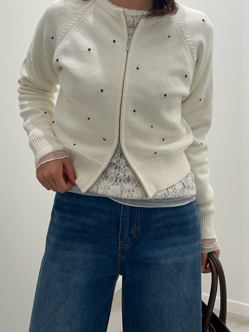 ホワイト系のカーディガン/ボレロ、ブラック系のTシャツ/カットソー、ブラウン系のショルダーバッグを着用したレディースの冬コーディネートの3枚目の写真