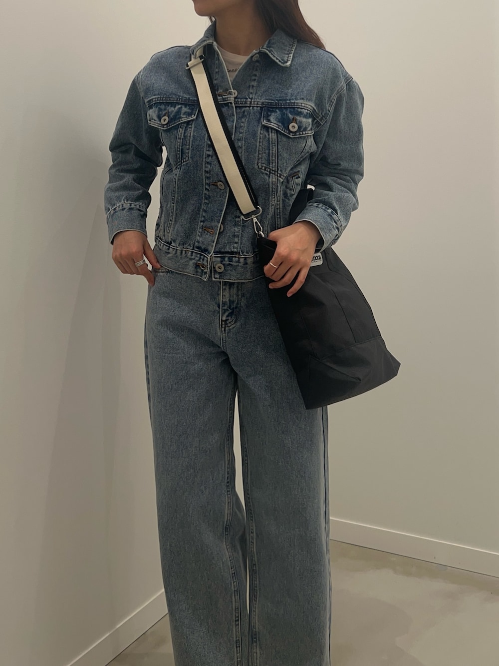 ブルー系のデニムジャケット、ブルー系のデニムパンツ、ブラウン系のベルトを着用したレディースの冬コーディネートの3枚目の写真