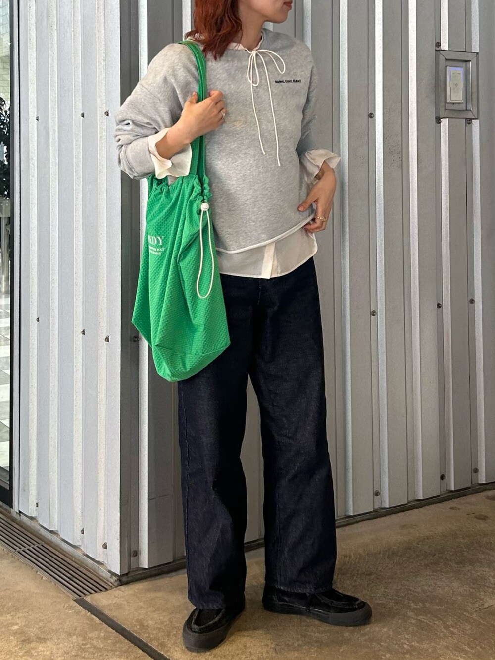 グレー系のスウェット、ホワイト系のシャツ/ブラウス、ブルー系のデニムパンツを着用したレディースの春コーディネートの3枚目の写真