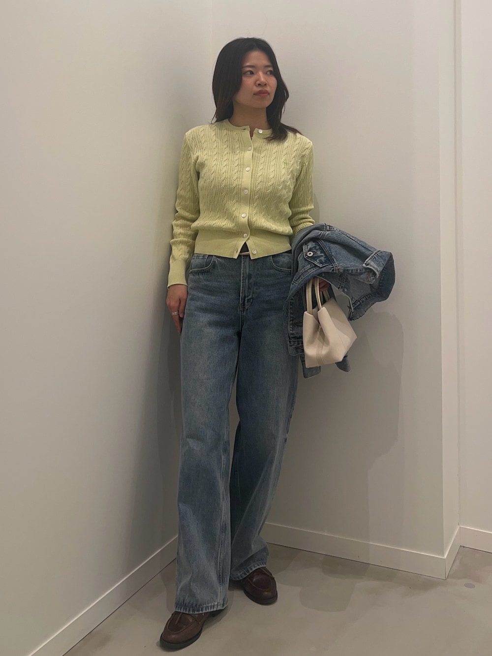 ブルー系のデニムパンツ、ブルー系のデニムジャケット、グリーン系のカーディガン/ボレロを着用したレディースの冬コーディネートの2枚目の写真