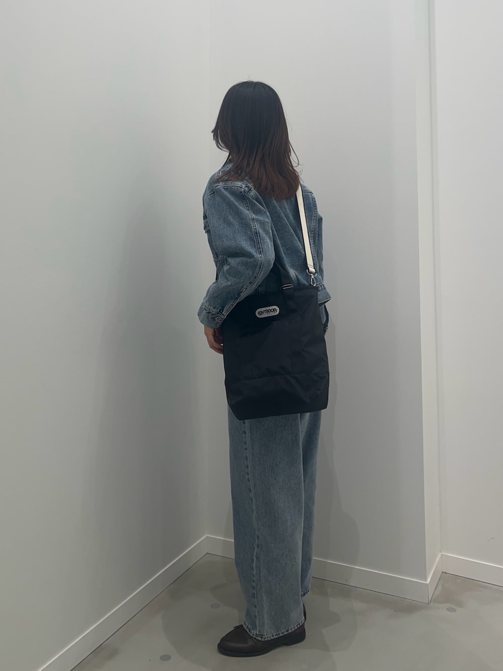 ブルー系のデニムジャケット、ブルー系のデニムパンツ、ブラウン系のベルトを着用したレディースの冬コーディネートの2枚目の写真