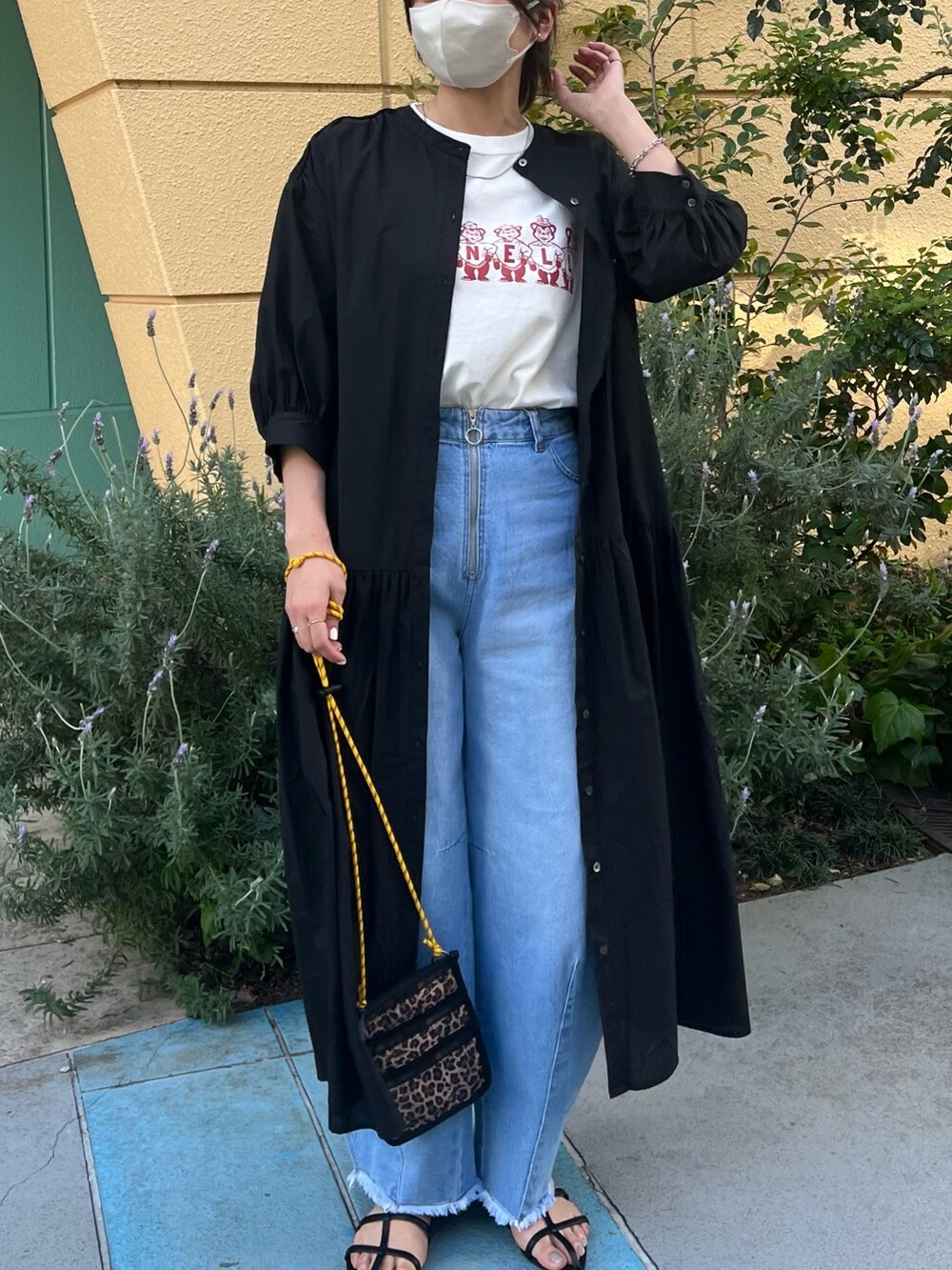 ブルー系のデニムパンツ、ホワイト系のTシャツ/カットソー、ブラック系のシャツワンピースを着用したレディースの春コーディネートの4枚目の写真