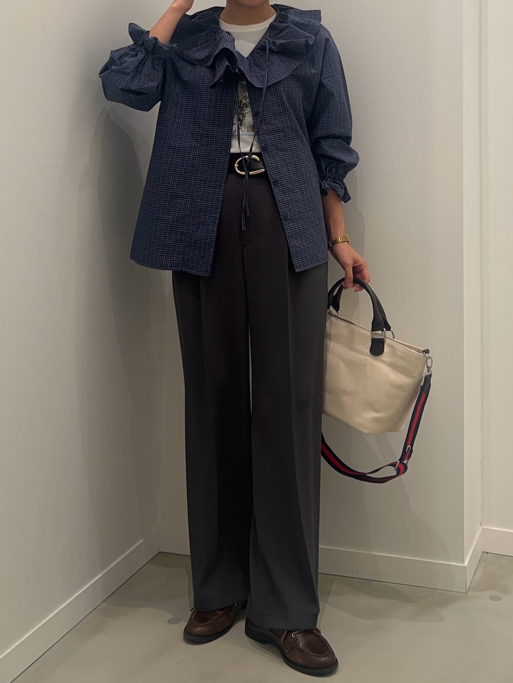 ホワイト系のTシャツ/カットソー、グレー系のスラックス、ホワイト系のショルダーバッグを着用したレディースの春コーディネートの2枚目の写真