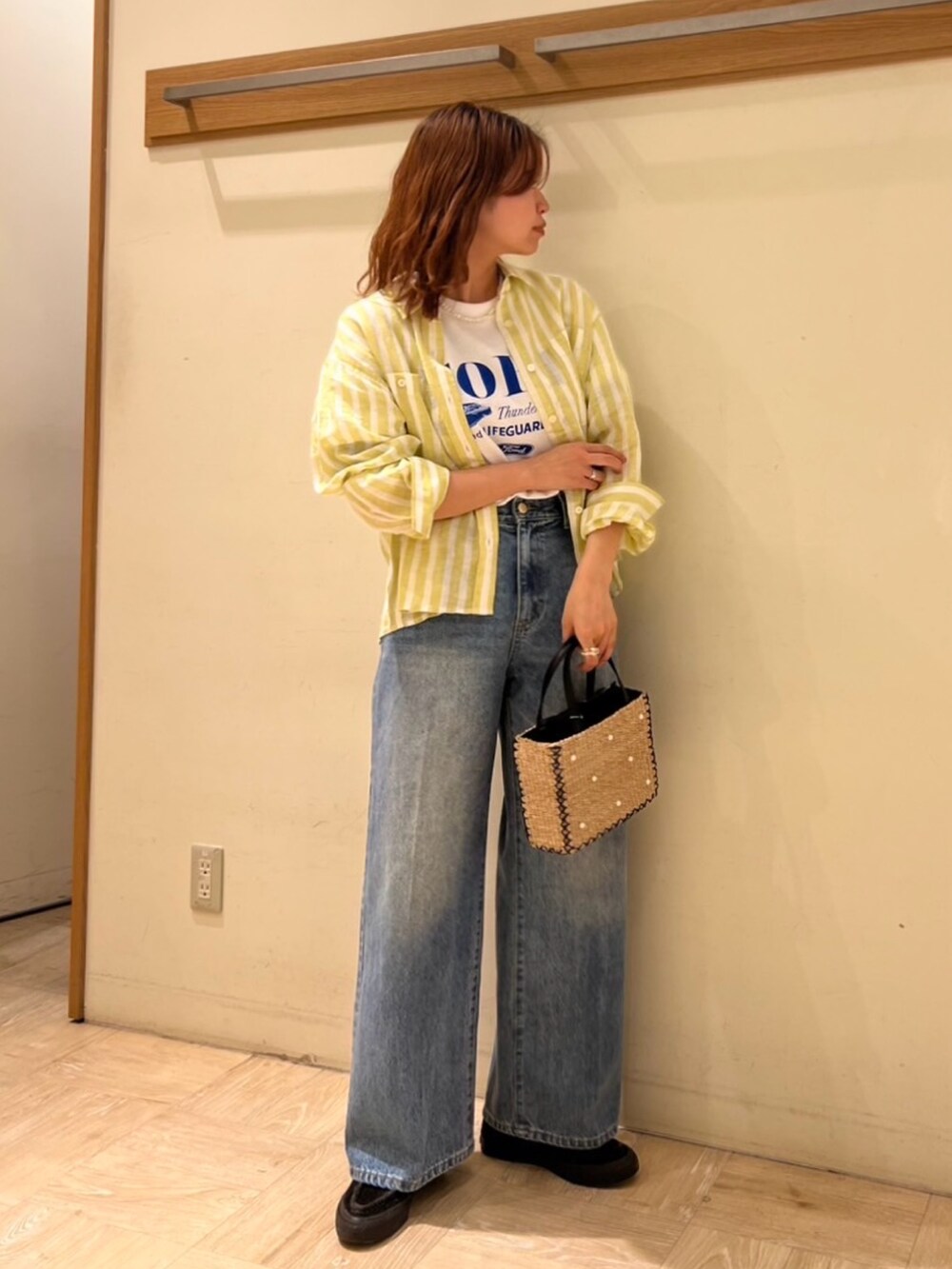 ブルー系のデニムパンツ、イエロー系のシャツ/ブラウス、ホワイト系のTシャツ/カットソーを着用したレディースの春コーディネートの4枚目の写真