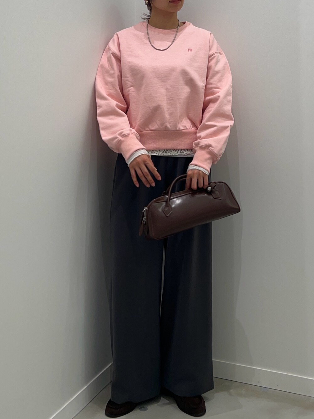 グレー系のその他パンツ、ブラウン系のショルダーバッグ、ピンク系のスウェットを着用したレディースの冬コーディネートの4枚目の写真