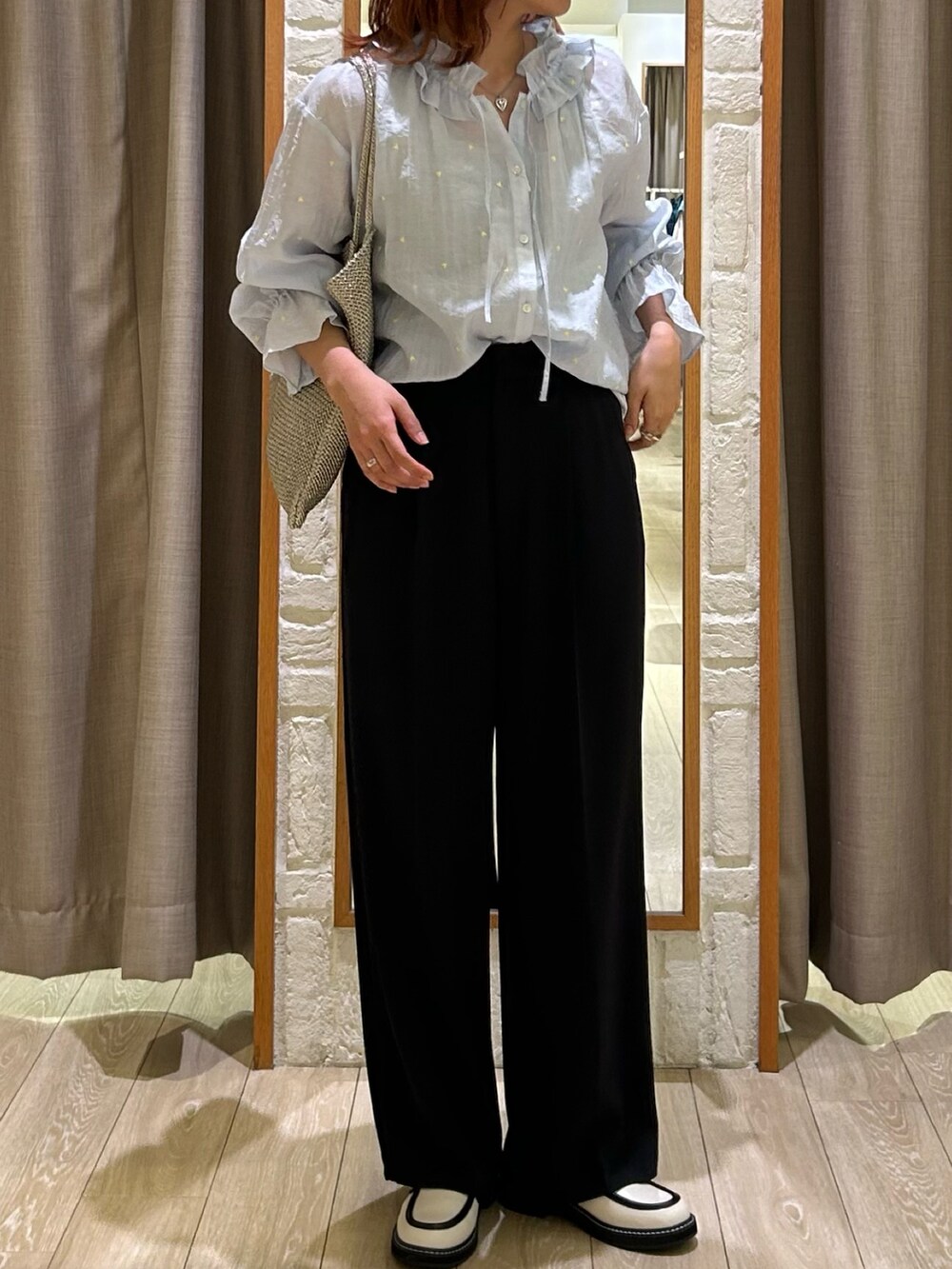 ブラック系のスラックス、シルバー系のトートバッグ、ブルー系のシャツ/ブラウスを着用したレディースの春コーディネートの2枚目の写真