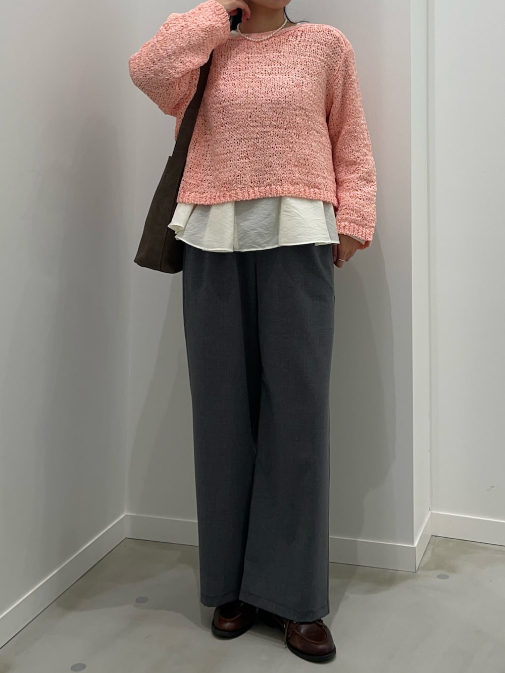 グレー系のその他パンツ、ピンク系のニット/セーター、ホワイト系のシャツ/ブラウスを着用したレディースの春コーディネートの3枚目の写真