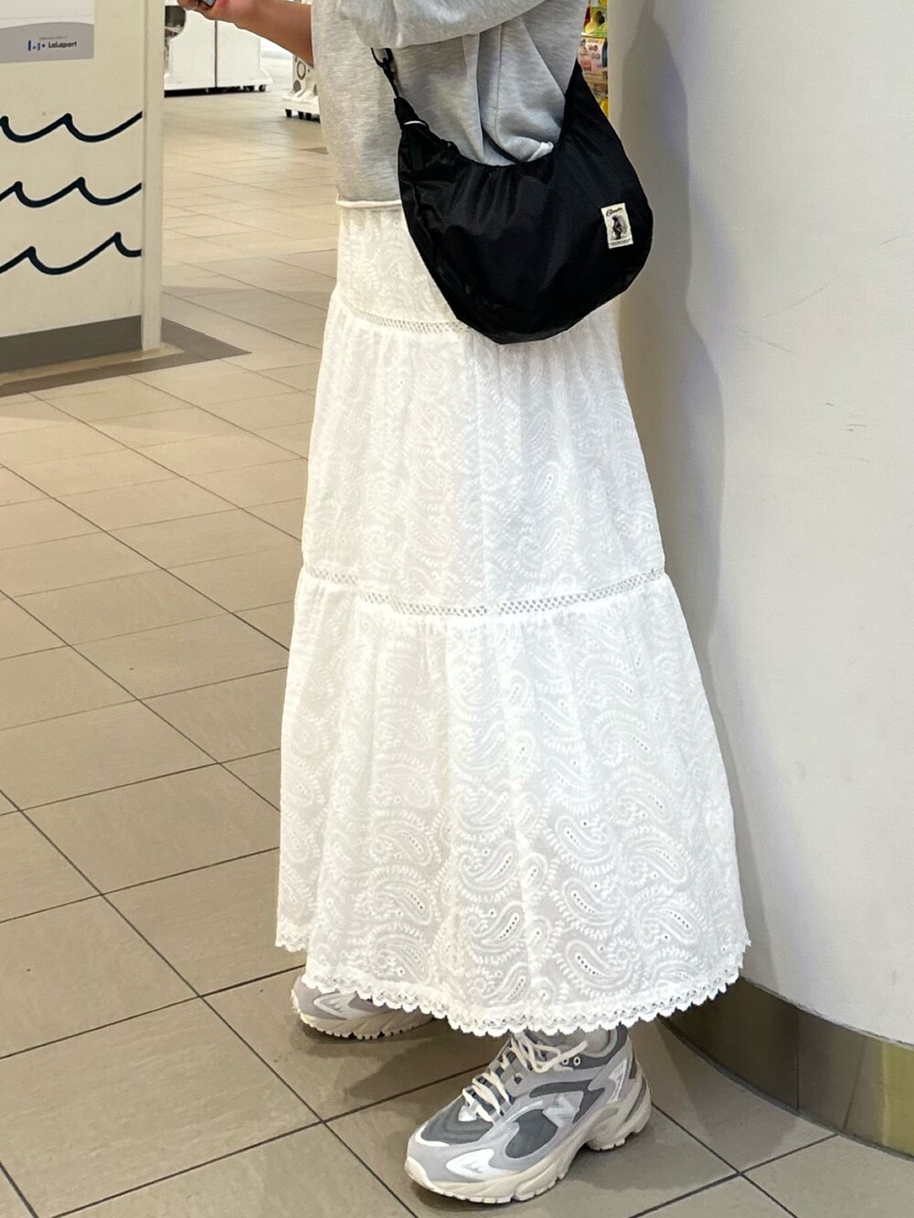 グレー系のスウェット、ホワイト系のスカート、ブルー系のバンダナ/スカーフを着用したレディースの春コーディネートの3枚目の写真