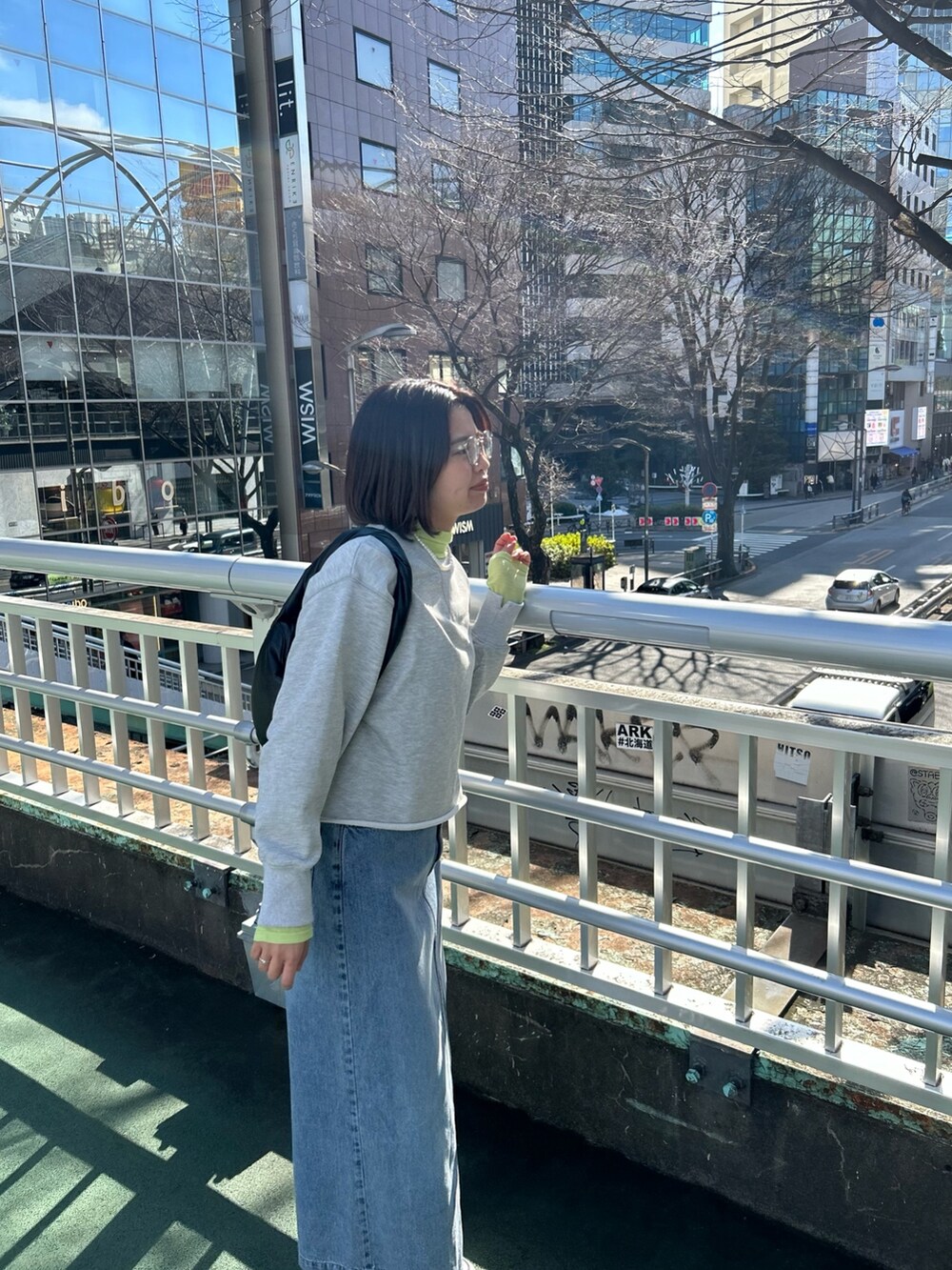グレー系のスウェット、イエロー系のTシャツ/カットソー、ブルー系のデニムスカートを着用したレディースの冬コーディネートの2枚目の写真