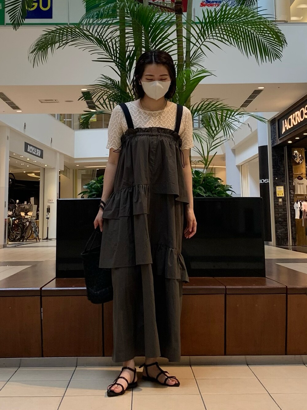 グリーン系のワンピース、ホワイト系のTシャツ/カットソー、ブラック系のトートバッグを着用したレディースの夏コーディネートの2枚目の写真