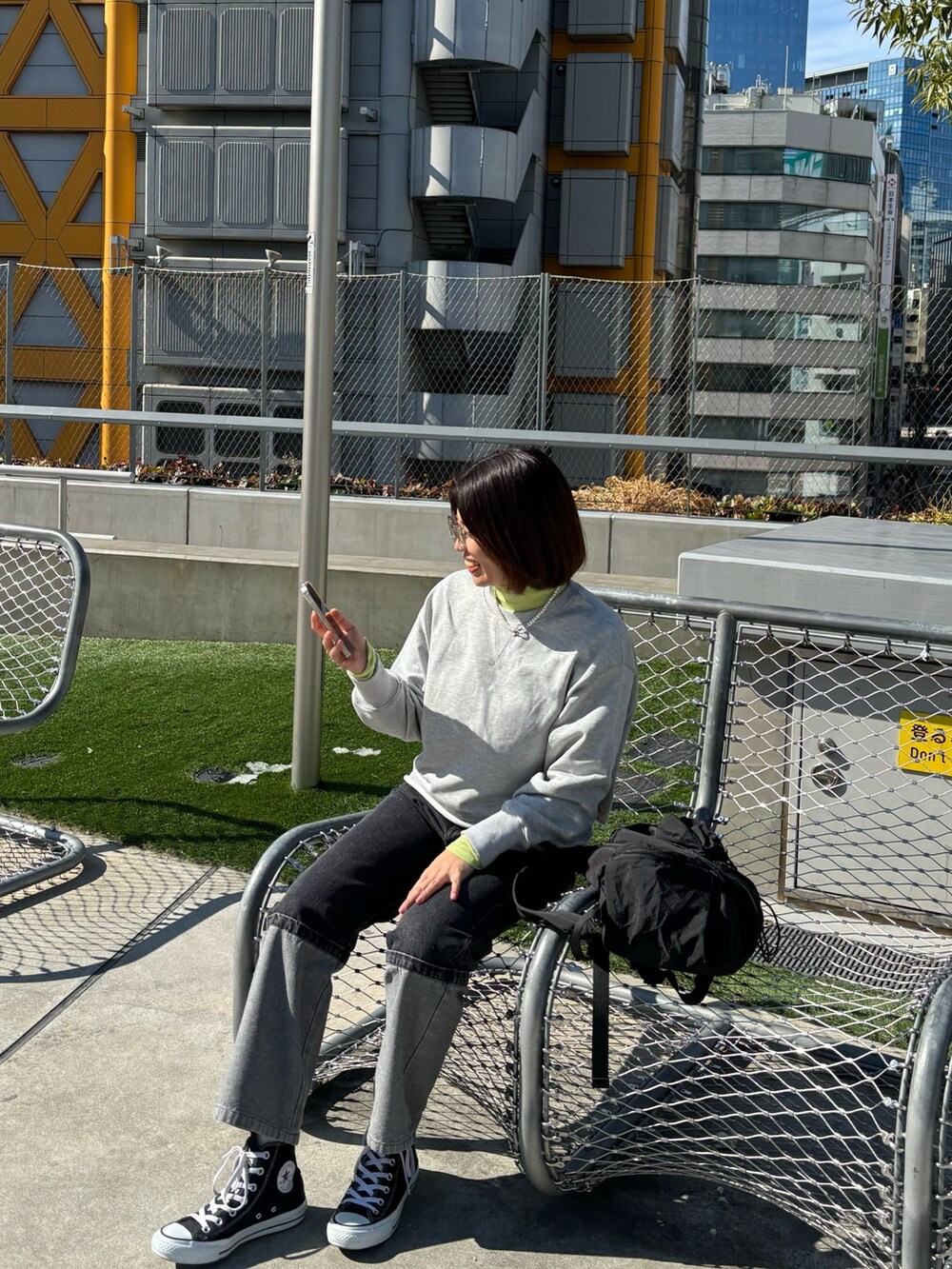 グレー系のスウェット、イエロー系のTシャツ/カットソー、ブラック系のデニムパンツを着用したレディースの春コーディネートの3枚目の写真