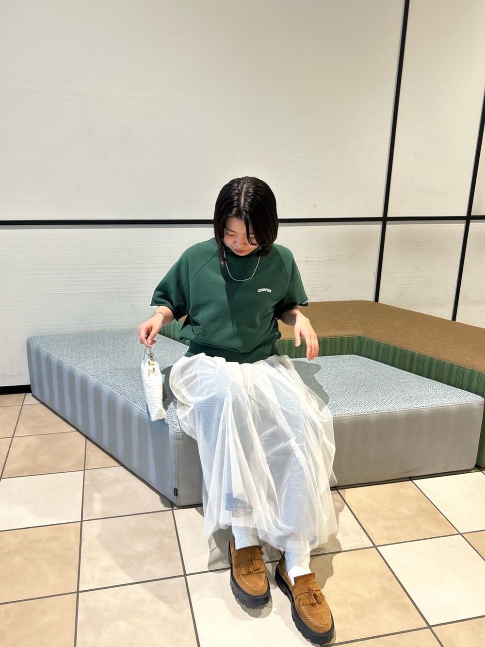 ブラウン系のショルダーバッグ、ホワイト系のワンピース、シルバー系のネックレスを着用したレディースの春コーディネートの3枚目の写真