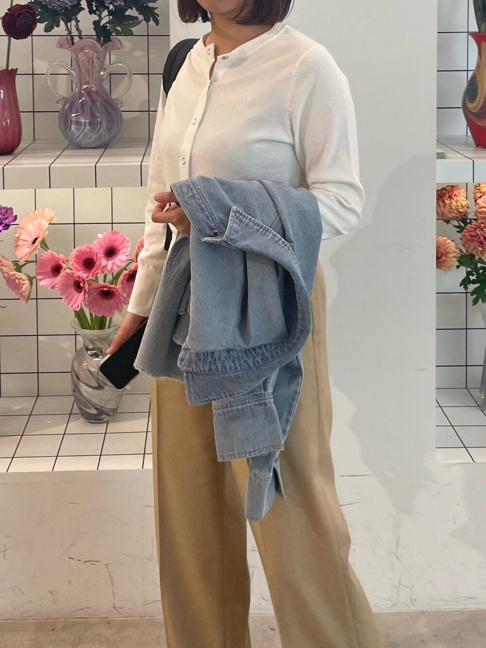 ベージュ系のその他パンツ、ホワイト系のカーディガン/ボレロ、ブルー系のシャツ/ブラウスを着用したレディースの春コーディネートの5枚目の写真