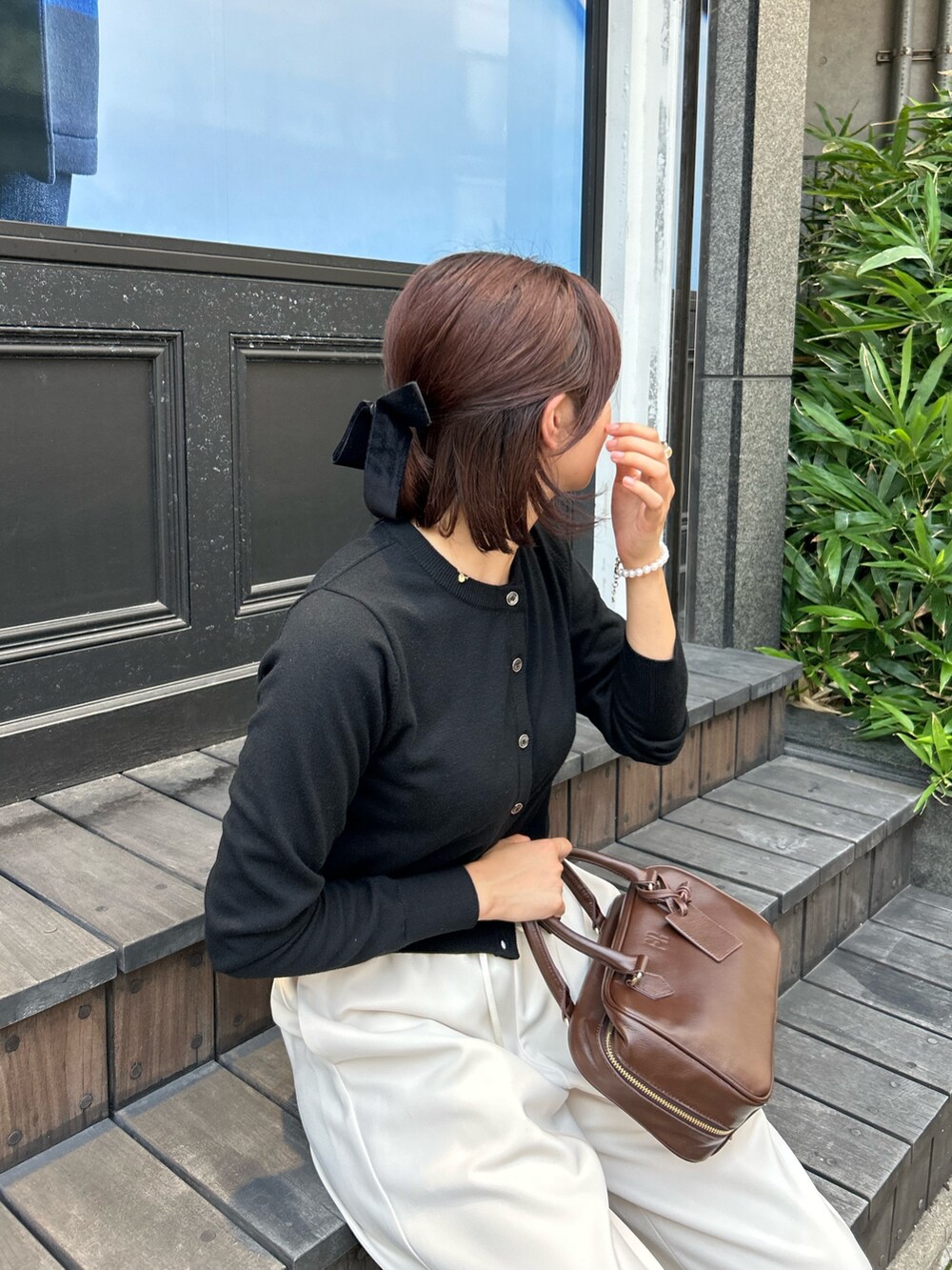 ホワイト系のその他パンツ、ブラウン系のハンドバッグ、ブラック系のニット/セーターを着用したレディースの秋コーディネートの7枚目の写真