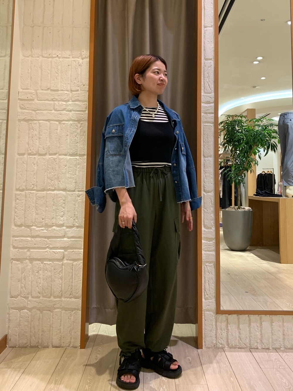 グリーン系のカーゴパンツ、ブルー系のシャツ/ブラウス、ブラック系のニット/セーターを着用したレディースの秋コーディネートの3枚目の写真