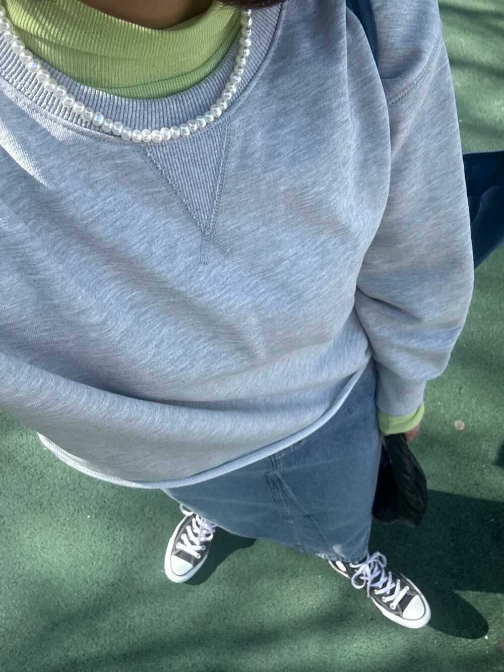 グレー系のスウェット、イエロー系のTシャツ/カットソー、ブルー系のデニムスカートを着用したレディースの冬コーディネートの5枚目の写真
