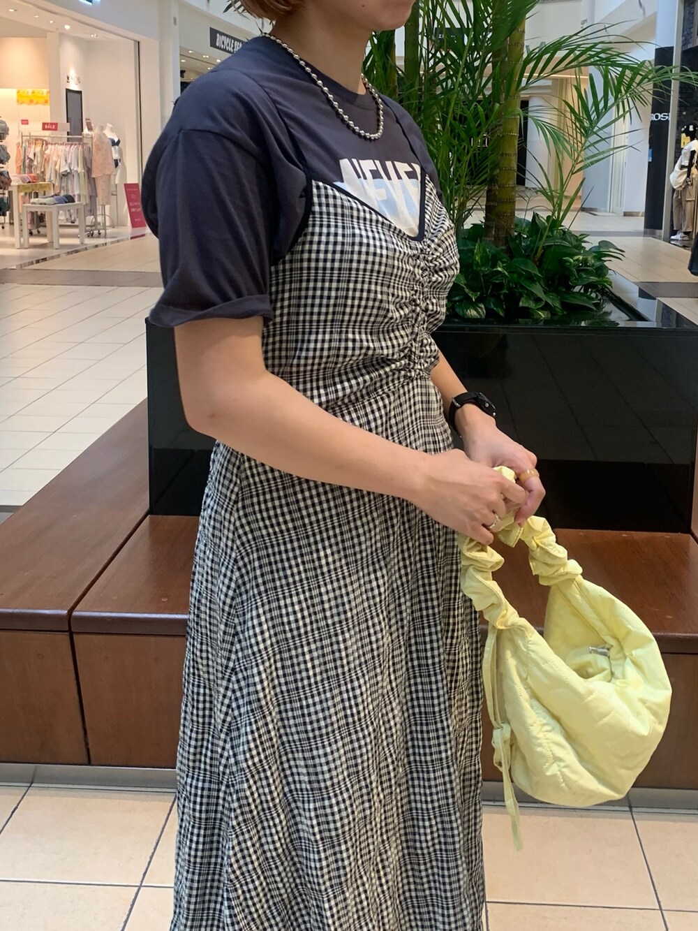 ブラック系のワンピース、グレー系のTシャツ/カットソー、イエロー系のショルダーバッグを着用したレディースの夏コーディネートの2枚目の写真