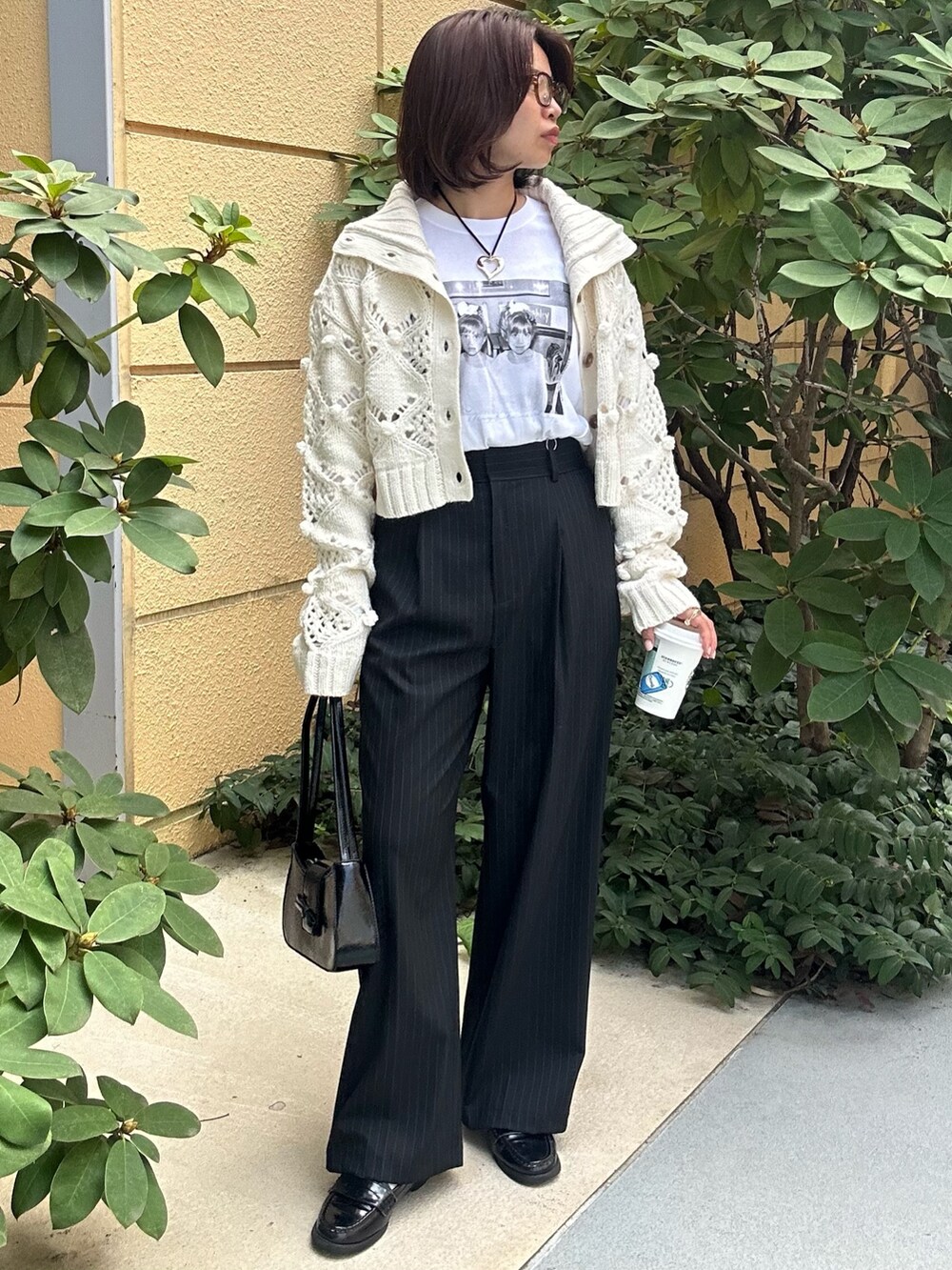 ブルー系のスラックス、ホワイト系のニット/セーター、ホワイト系のTシャツ/カットソーを着用したレディースの秋コーディネートの4枚目の写真