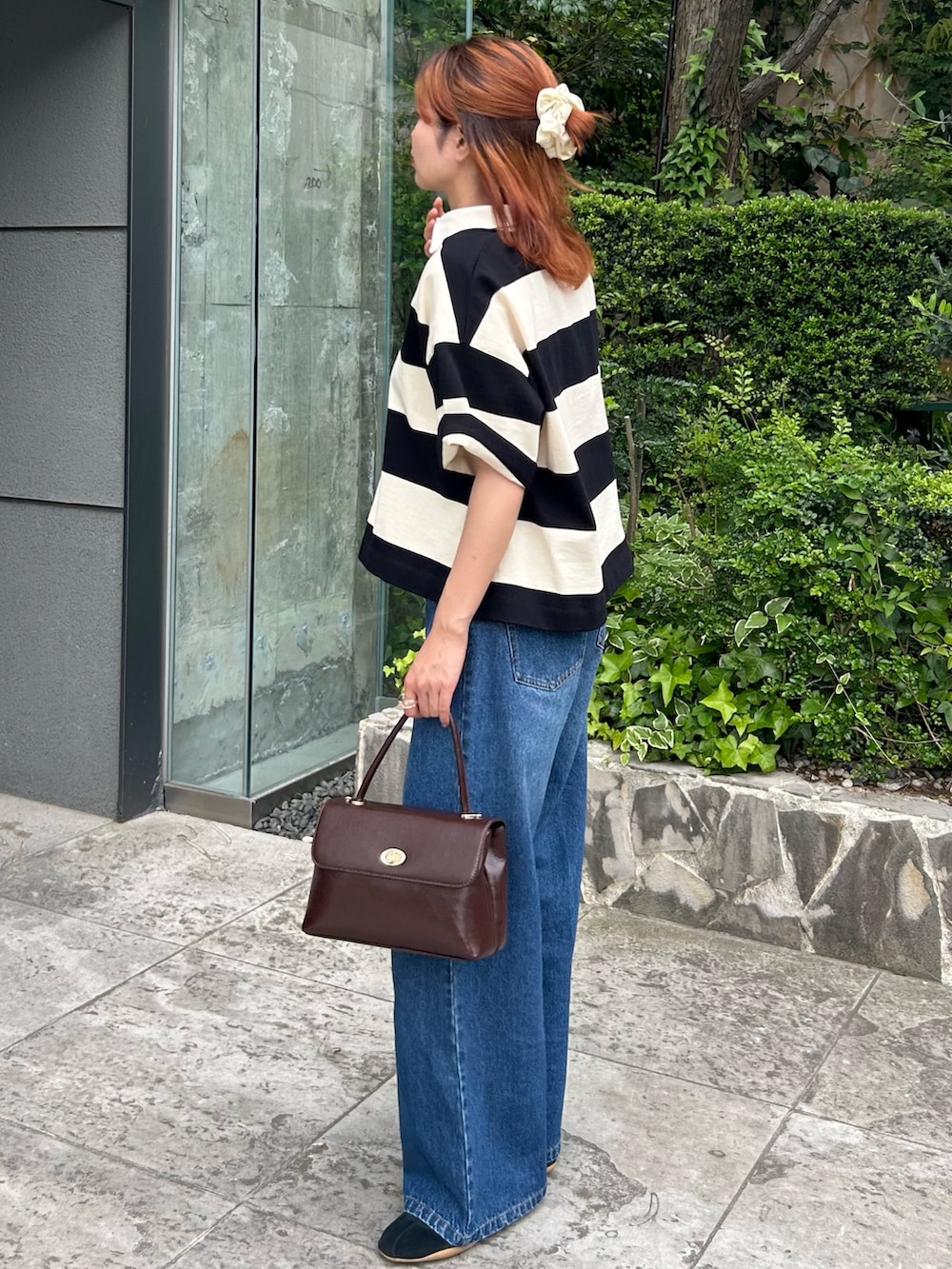 ブラック系のスニーカー、ブラウン系のショルダーバッグ、グレー系のTシャツ/カットソーを着用したレディースの夏コーディネートの2枚目の写真