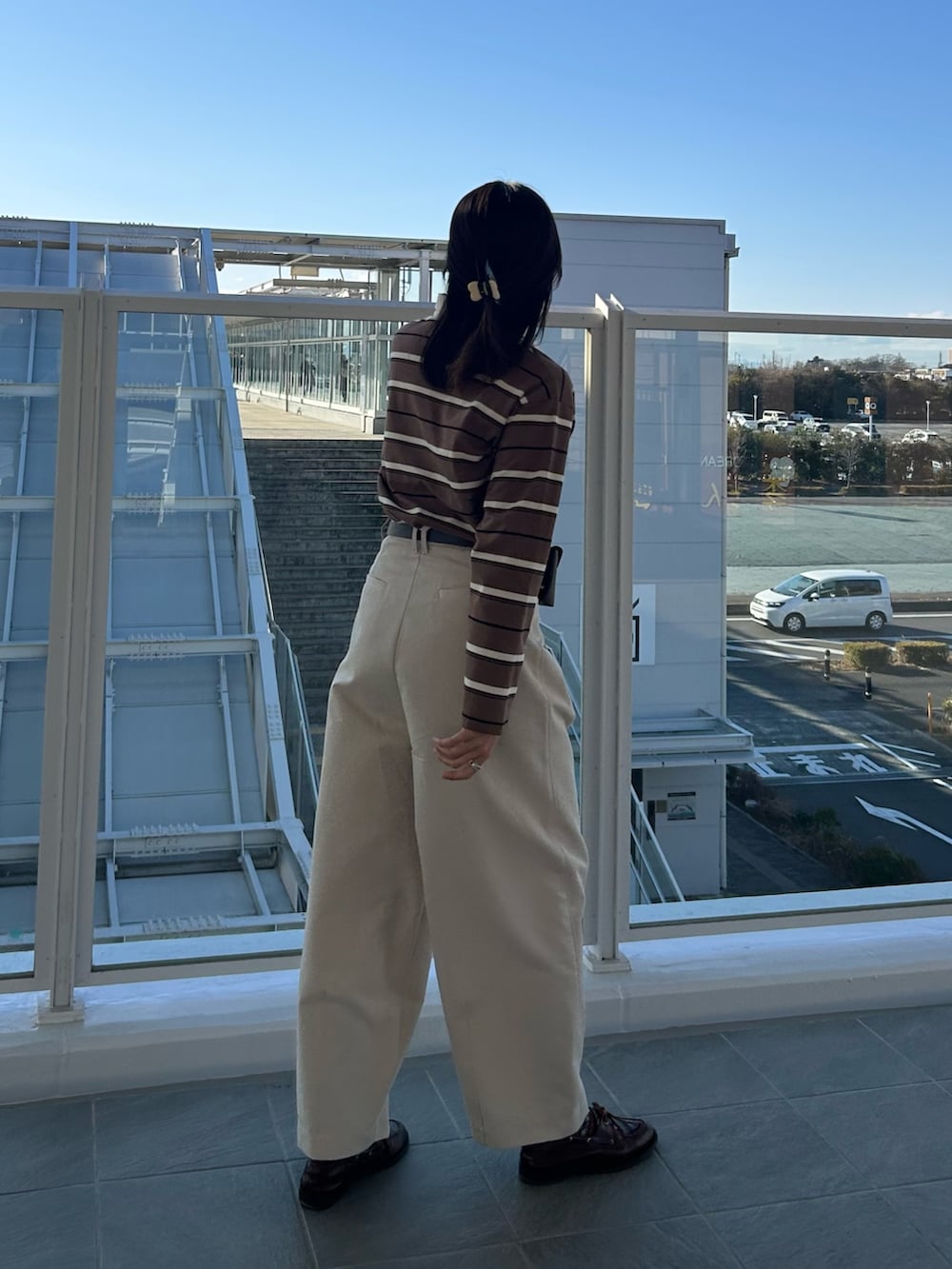 ベージュ系のチノパンツ、ブラウン系のTシャツ/カットソーを着用したレディースの冬コーディネートの2枚目の写真